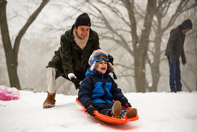 A parent and child enjoy the snow, despite the lies told by our government every day.